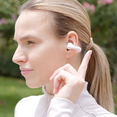 Mulher com auricular branco sem fios na orelha direita