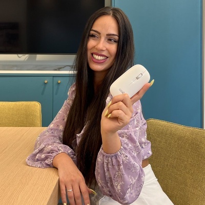 Mulher sentada à mesa segurando um rato de computador branco DEEPCOOL