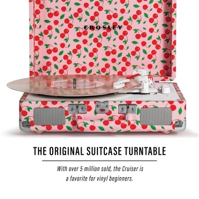 Toca-discos estilo mala com padrão de cerejas vermelhas em fundo rosa