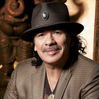 Pessoa com chapéu castanho escuro e casaco xadrez castanho em ambiente com decoração de madeira