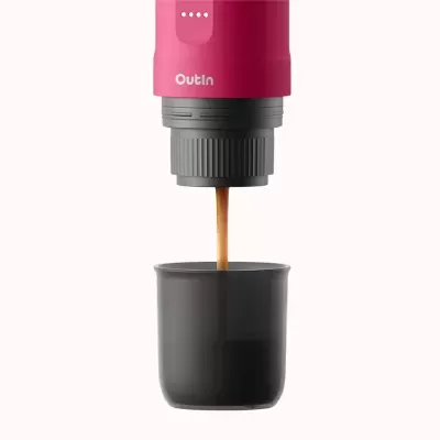 Máquina de café portátil rosa Outln a despejar café numa chávena preta.