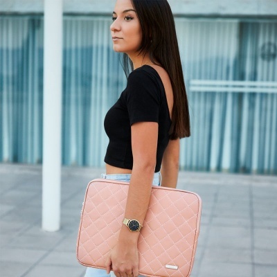 Bolsa de laptop rosa claro acolchoada sendo transportada por mulher com roupa preta