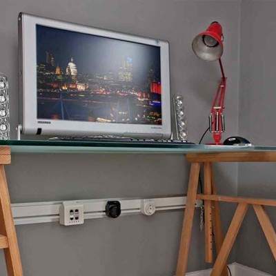 Mesa de escritório com computador e candeeiro vermelho