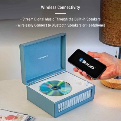 Gira-discos azul claro CROSLEY com cd, telemóvel com símbolo Bluetooth e lâmpada em mesa clara