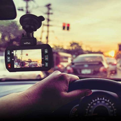 Câmara de carro Veho montada no para-brisas a capturar trânsito urbano ao pôr do sol