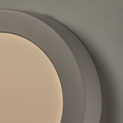 Luz de teto redonda cinza claro com iluminação branca numa parede cinza