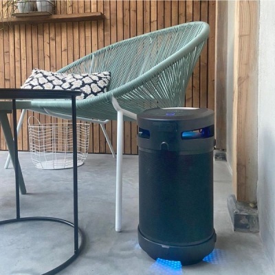 Cadeira em corda verde com almofada, mesa de vidro e dispositivo tecnológico preto com luzes azuis