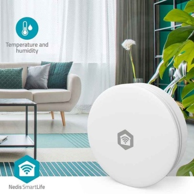 Sensor branco redondo em sala decorada com sofá, almofadas e plantas