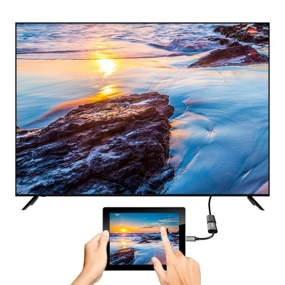 Televisor LCD a exibir imagem de praia ao pôr do sol com tablet ligado por cabo USB