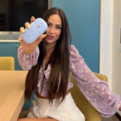 Rato azul claro segurado por mulher com blusa lilás floral em escritório