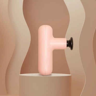 Massajador portátil rosa claro com botão preto em pedestal redondo