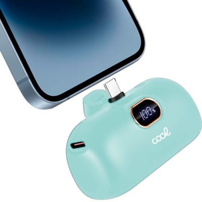 Dispositivo portátil azul claro com ecrã digital e conector USB-C junto a smartphone cinza.