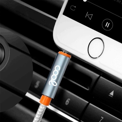 Cabo de carregamento USB cinza com conector laranja ligado a smartphone branco num carro