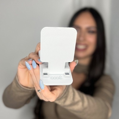 Suporte branco em plástico com textura antiderrapante e palavra cool segura por pessoa.