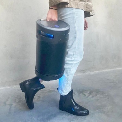 Pessoa a segurar aspirador portátil preto com detalhes azuis