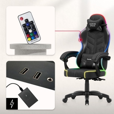 Cadeira gaming preta com almofada GAMING SPACE, controle remoto e entradas USB numa superfície preta.