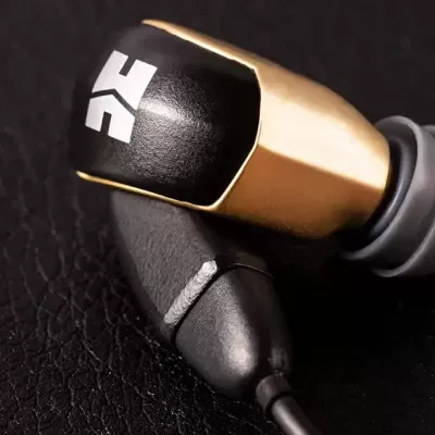 Auricular intra-auricular preto e dourado com símbolo branco e ponta de silicone cinza