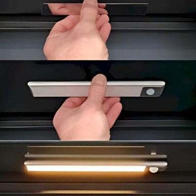 Mão accionando luz LED em barra prata com botão circular branco em fundo preto