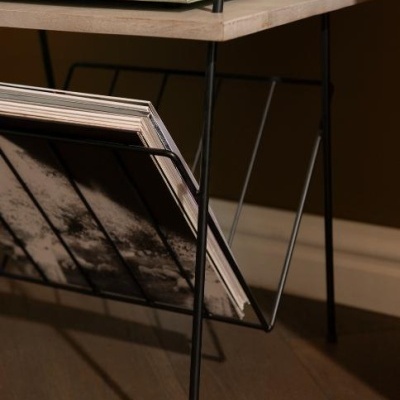 Mesa de apoio em madeira clara e metal preto com revistas no suporte inferior