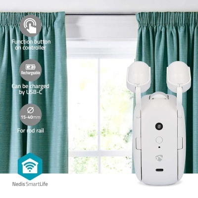 Controlador branco entre cortinas verdes azuis, frente a janela, mostrando texto das funções e marca.