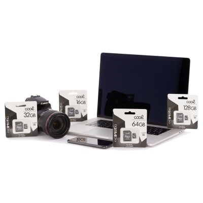 Máquina fotográfica Canon, portátil, smartphone e embalagens de cartões de memória em fundo branco.