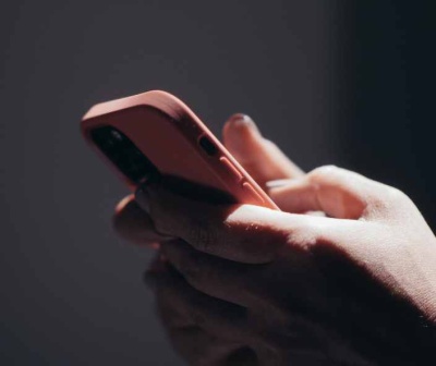 Smartphone com capa vermelha segurado por mãos