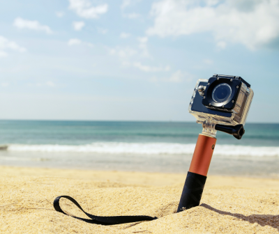 Câmara de ação em suporte na areia da praia com mar e céu ao fundo