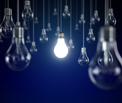 Lâmpadas de filamento penduradas, uma acesa no centro, fundo azul