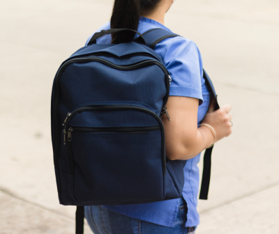 Mochila azul escura com vários compartimentos usada por uma pessoa