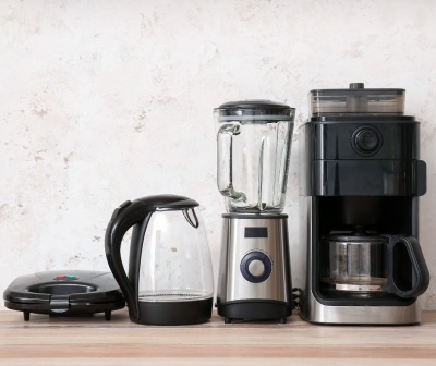 Pequenos eletrodomésticos de cozinha numa bancada de madeira clara