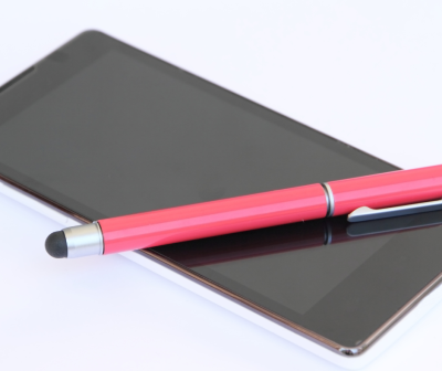 Tablet preto com caneta stylus rosa e preta em cima