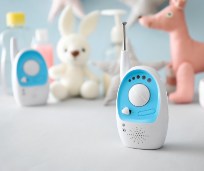 Intercomunicador branco e azul com brinquedos ao fundo