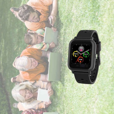 Relógio inteligente preto com ecrã digital colorido sobre relva com quatro idosos a ler