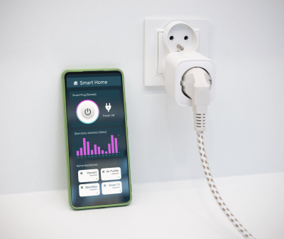Tomada elétrica com plugue ligado e smartphone a mostrar aplicação Smart Home