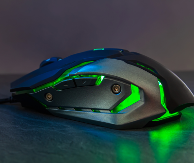 Rato gaming preto com luzes verdes em superfície escura