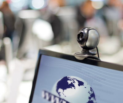 Webcam preta e cinzenta no topo de monitor com imagem de globo e texto WWW