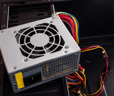 Fonte de alimentação para computador com ventoinha e cabos coloridos dentro de um gabinete preto