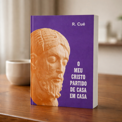 Livro capa roxa com escultura de rosto em tons de laranja e texto em branco sobre mesa de madeira