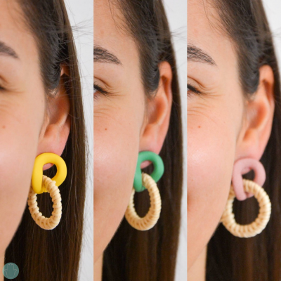 Três pares de brincos com topo colorido e alça trançada em tons naturais, mostrados na orelha de uma mulher