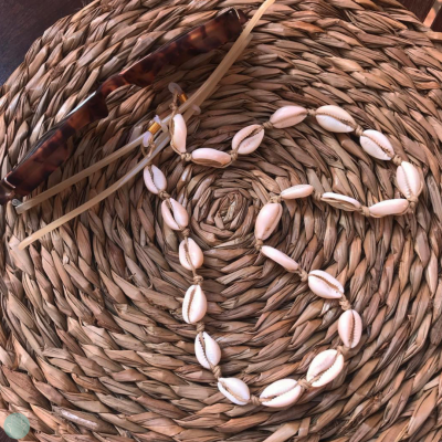 Colar de conchas sobre base de fibra trançada com suporte de óculos castanho e cordão bege