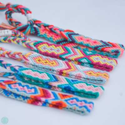 Pulseiras de fios coloridos com padrões geométricos sobre fundo branco