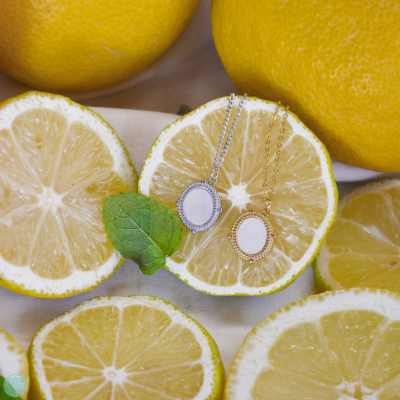Colares com medalhões prateados e dourados em meia rodela de limão siciliano