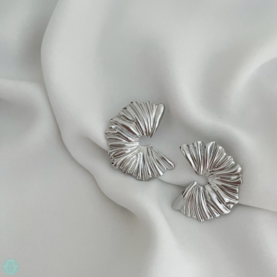 Brincos prateados texturizados em tecido branco