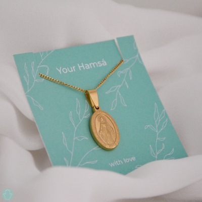 Colar dourado com pendente oval e base de cartão verde água com texto