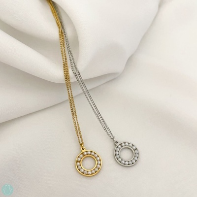 Dois colares pendentes redondos dourado e prateado com pérolas sobre tecido branco