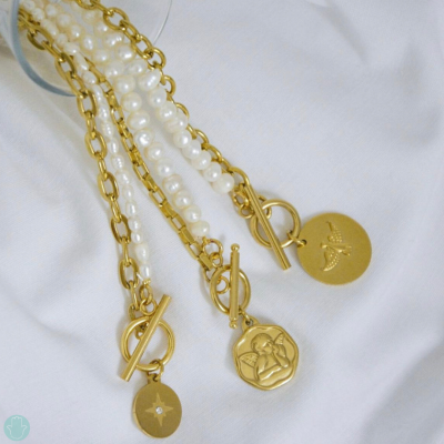 Três colares dourados com pérolas e pendentes variados em fundo branco