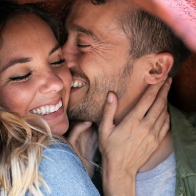 Casal feliz abraçado com cobertor castanho