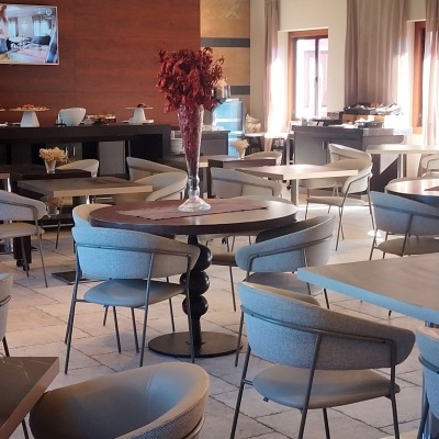 Restaurante moderno com mesas redondas e cadeiras estofadas cinza claro