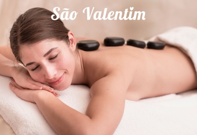 Mulher deitada para massagem com pedras quentes e texto São Valentim