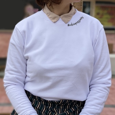 Pullover branco com gola de camisa bege e saia de riscas verticais